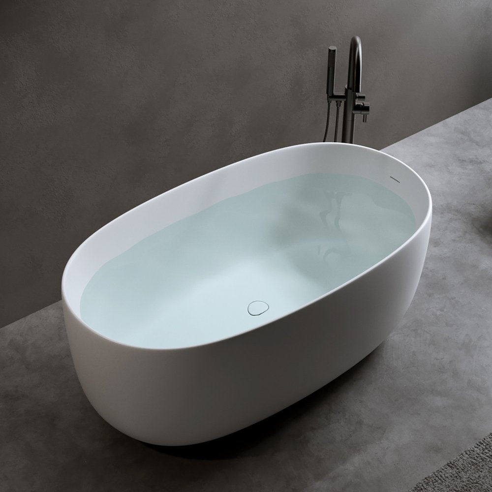 White freestanding oval bathtub with a floor-mounted tub filler