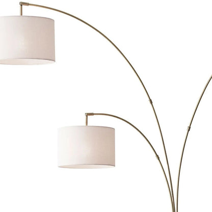 74" Brass Three Light Arc Floor Lamp With Off White Fabric Drum Shade HomeRoots