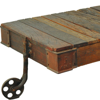 50" Brown and Black Solid Wood and Iron Distressed Wheel Coffee Table HomeRoots