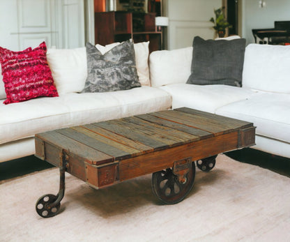50" Brown and Black Solid Wood and Iron Distressed Wheel Coffee Table HomeRoots