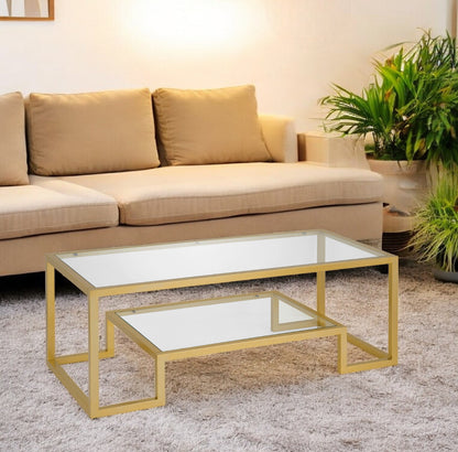 45" Clear And Gold Glass And Steel Sled Coffee Table With Shelf